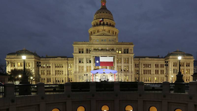 FILE - In this Jan. 14, 2019 file photo, a large Texas flag hangs from the Texas State Capitol...